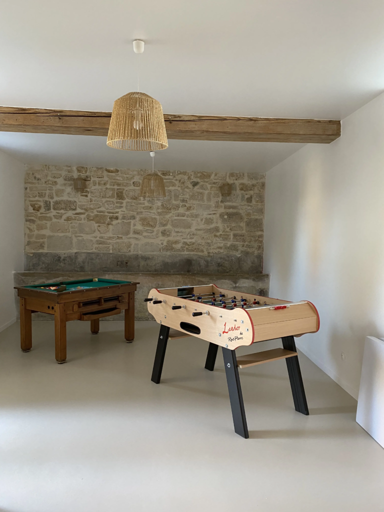Billard et baby-foot dans la salle en pierre du gîte Le Clos de l'église